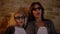 Closeup shoot of young caucasian female and her small daughter watching TV in 3D glasses getting excited and scared