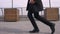 Closeup shoot of young cheerful attractive african american businessman performing a moonwalk on the street in the urban