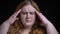 Closeup shoot of young overweight caucasian female overthinking and getting a headache in front of the camera