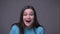 Closeup shoot of young pretty brunette female smiling being excited looking at camera with background isolated on gray