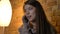 Closeup shoot of young pretty caucasian female calling on the phone and smiling happily in a cozy apartment indoors