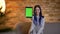 Closeup shoot of young pretty caucasian female with dyed hair using the tablet and showing a green screen to camera