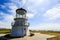 Closeup of short coastal lighthouse along shore of California