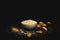 Closeup shot of almonds next to a glass bowl of ground almonds in front of a black background