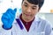 Closeup shot of Asian happy young successful professional male scientist student face in white lab coat and blue rubber gloves