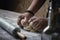 Closeup shot of a baker mixing the dough with flour