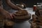 Closeup shot of a baker serving a sliced homemade loaf of bread on a wooden table