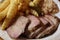 Closeup shot of barbeque pork dish with coleslaw and french fries on a plate