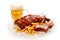 Closeup shot of barbeque pork spareribs and French fries served with a glass of lager beer