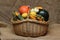 Closeup shot of a basket of full of assorted fruits and vegetables on a brown sack fabric surface