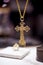 Closeup shot of a big golden Christian cross with depicted icons on a blurred background