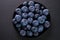 Closeup shot of a black ceramic plate with fresh organic blueberries from the Ecuadorian highlands.