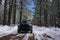 Closeup shot of a black Toyota Tacoma on a narrow snowy train in a forest in Big Bear