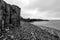 Closeup shot in black and white of rocky basalt volcanic textured columns in Kalfshamarsvik in Iceland during heavy rain