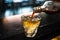 Closeup shot of blended whiskey being poured in a glass from a bottle with blurred background