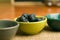 Closeup shot of a bowl of blueberries near empty bowls on a wooden surface