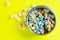 Closeup shot of a bowl with colorful marshmellows on a yellow background