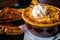 Closeup shot of a bowl of soup with shredded cheese and sour cream on top beside grilled cheese