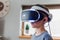 Closeup shot of a boy standing seriously in the room while wearing the virtual reality headset