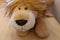 Closeup shot of a brown cuddly plush lion toy on a wooden surface