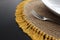 Closeup shot of a brown knit placemat with yellow tassels