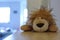 Closeup shot of a brown plush lion toy laying on a wooden surface