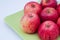 Closeup shot of a bunch of juicy red apples on a cutting board