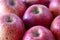 Closeup shot of a bunch of juicy red apples on a cutting board