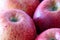 Closeup shot of a bunch of juicy red apples on a cutting board