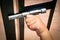 Closeup shot of a child\'s hand closing a silver sliding latch on a gate