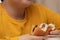 Closeup shot of a child wearing a yellow shirt eating a homemade hamburger