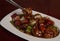 Closeup shot of Chinese chopsticks and a veal dish with peppers in a bean sauce
