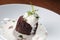 Closeup shot of a chocolate and nut bread with vanilla ice cream and choco chips on a white plate