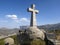 Closeup shot of a Christian stone cross on a hill under blue sky