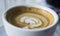 Closeup shot  of a coffee foam swirl in a white mug