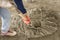 Closeup shot of a concrete being mixed up with a shovel. At the bare floor of a building under construction