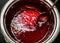 Closeup shot of cooking cherry jam in metal pan