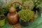 Closeup shot of a copper still for making perfumes and various herbs in pots