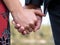 Closeup shot of a couple holding hands with an engagement ring - love concept