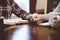 Closeup shot of a couple holding hands over the table white reading their books