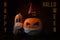 Closeup shot of Covid or coronavirus Halloween pumpkin lanterns with a witch hat and wearing a facemask with the title Happy