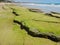 Closeup shot of a cracked shoreline covered with green algae