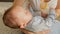 Closeup shot of cute baby boy lying on mothers hands and eating milk from bottle