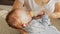 Closeup shot of cute baby boy lying on mothers hands and eating milk from bottle