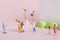 Closeup shot of cute figurines playing with balloons on a pink surface