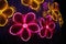 Closeup shot of decorative neon flowers at a park at night
