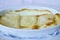 Closeup shot of a delicious croatian cheese pie placed on a white plate with a blurred background