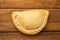 Closeup shot of a delicious empanada isolated on a wooden surface