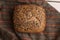 Closeup shot of delicious freshly-made artisanal brown bread with nuts on a wooden surface