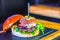 Closeup shot of a delicious open burger with fresh ingredients attached with skewers stick